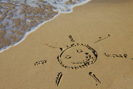 Aufsicht auf einen Strand, in den Sand ist eine Sonne geritzt