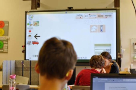 Ein Schüler blickt auf das digitale Smartboard in seinem Klassenraum